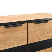 Nahaufnahme eines Highboards aus Holz mit schwarzen Griffen, Perspektive von vorne oben.