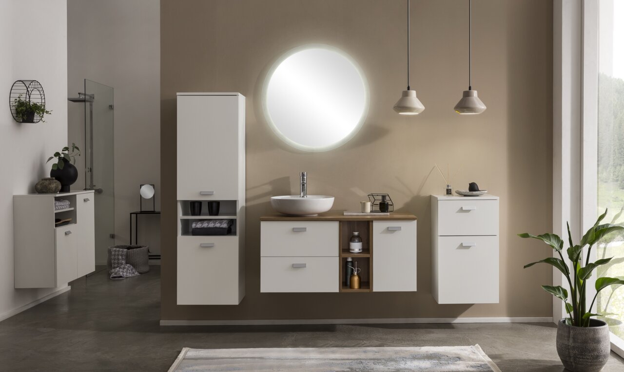 Rundes Spiegelelement mit Beleuchtung, zentral über einem modernen Waschbecken in einem stilvollen Badezimmer, seitliche Perspektive.