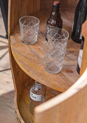 Nahaufnahme eines Bar-Fasses aus Holz mit Gläsern und Flaschen, von oben betrachtet.