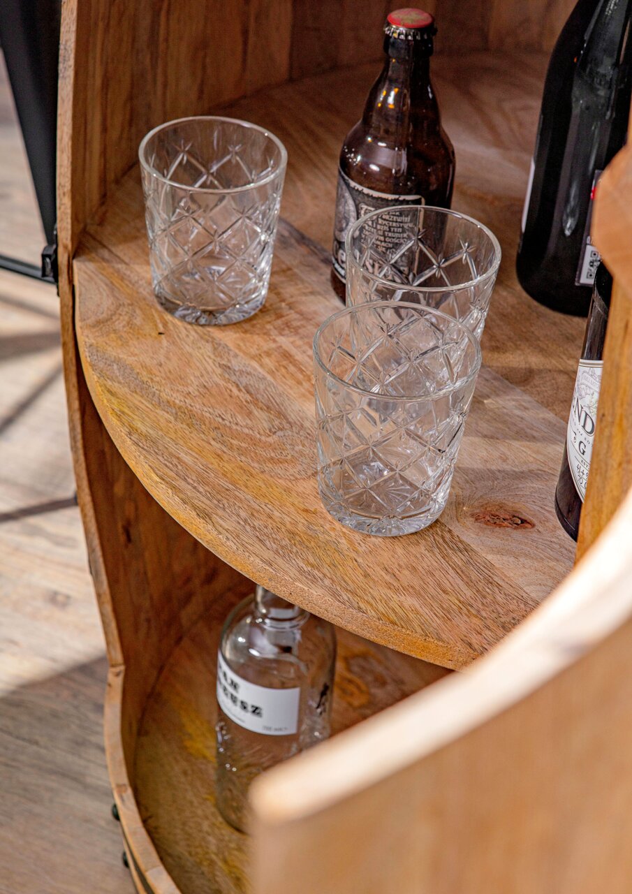 Nahaufnahme eines Bar-Fasses aus Holz mit Gläsern und Flaschen, von oben betrachtet.