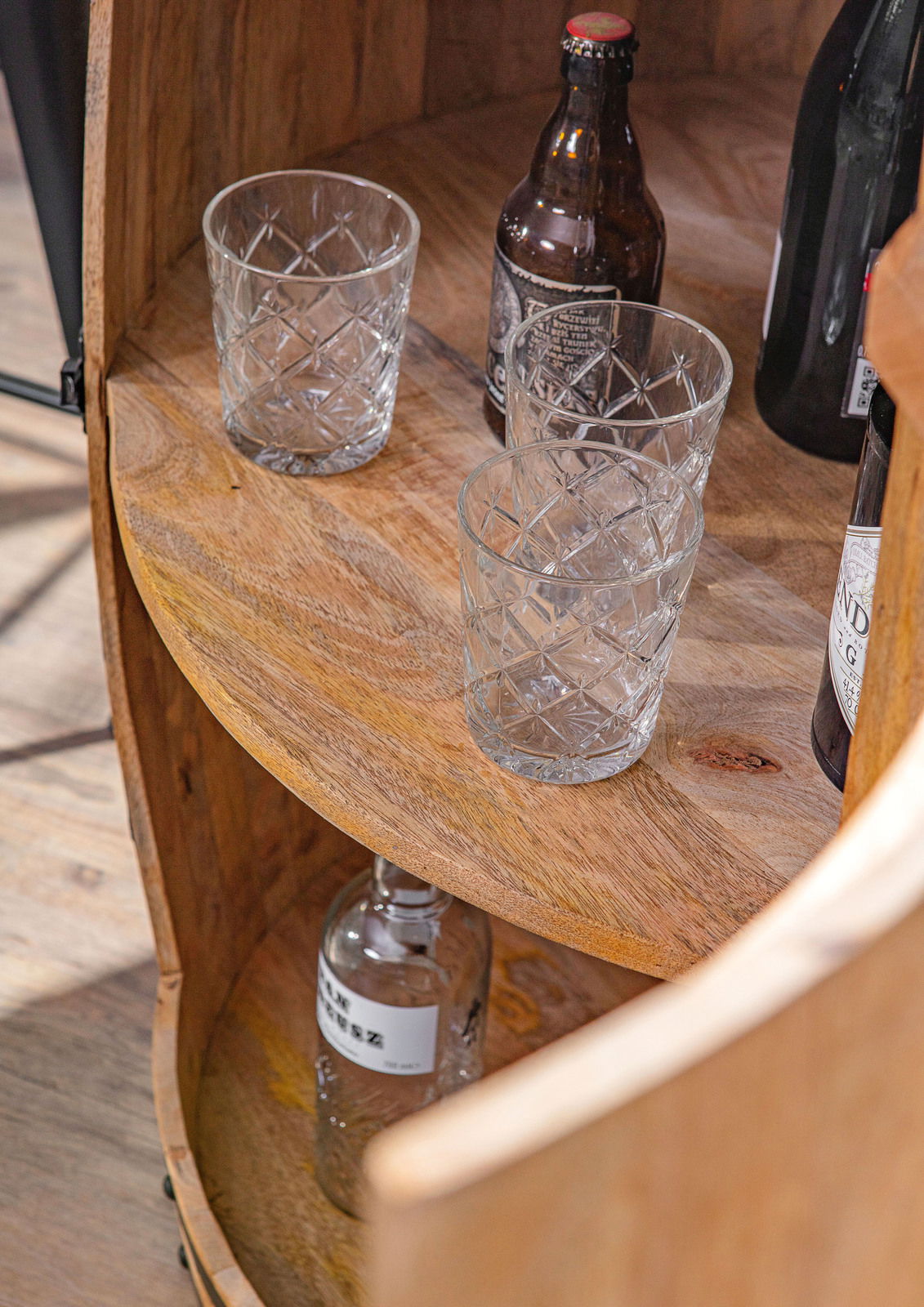 Nahaufnahme eines Bar-Fasses aus Holz mit Gläsern und Flaschen, von oben betrachtet.