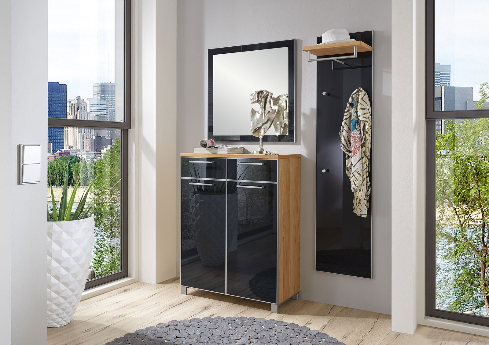 Moderner Eingangsbereich mit einem schwarzen Garderobenpaneel und einem Spiegel, daneben ein eleganter Schuhschrank mit Holz- und Glaselementen. Perspektive von vorne.