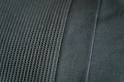 Nahaufnahme von grauer Bettwäsche mit strukturiertem und glattem Stoff, von oben betrachtet.