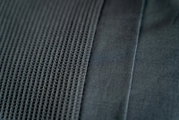 Nahaufnahme von grauer Bettwäsche mit strukturiertem und glattem Stoff, von oben betrachtet.