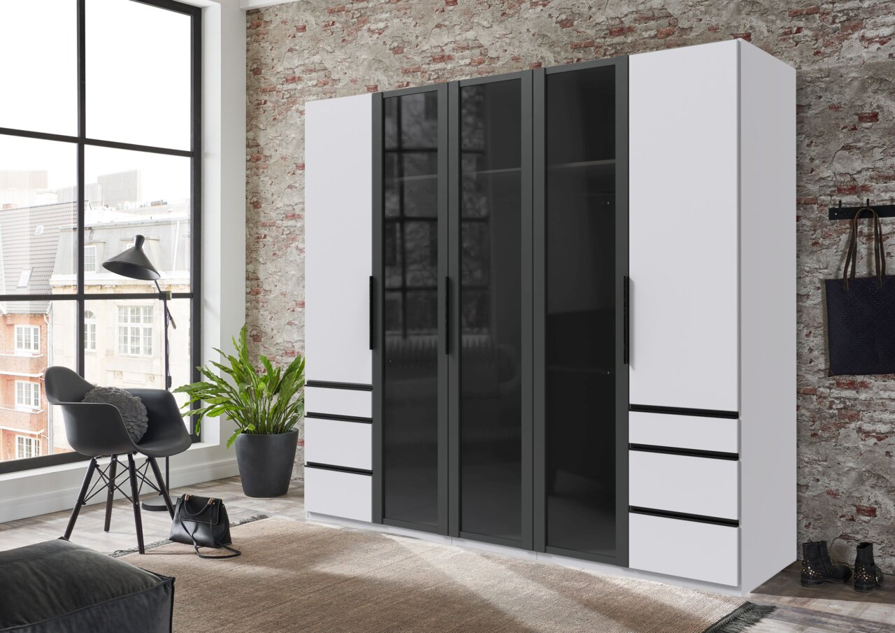 Moderne vijfdeurskast met draaideuren in zwart en wit, hier afgebeeld in een stijlvol ingerichte ruimte met een bakstenen muur en grote ramen.