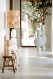 Stehlampe mit natürlichem Rattan-Lampenschirm in einem modernen, hellen Raum, seitliche Perspektive