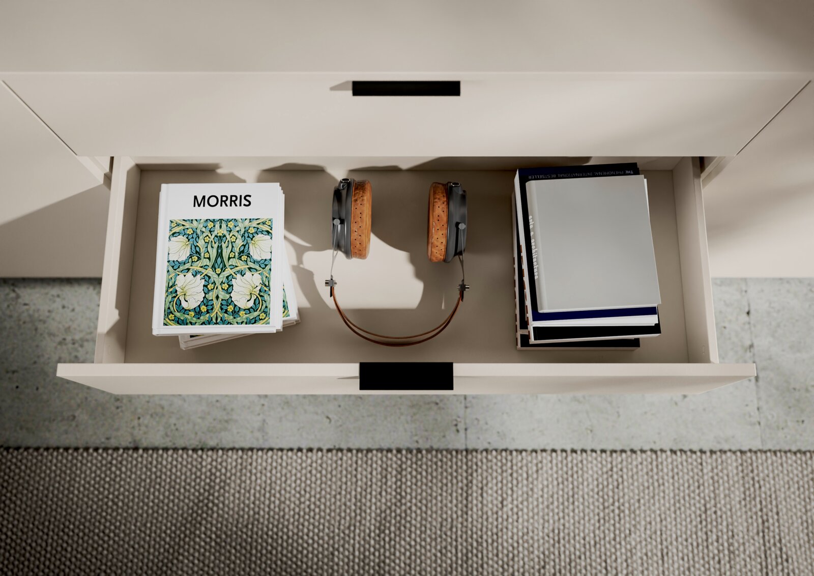 Een open lade van een tv-kast met boeken, koptelefoons en tijdschriften, gezien vanuit vogelperspectief.