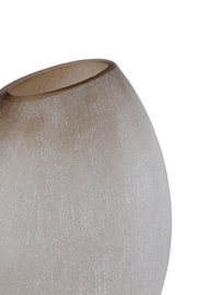 Nahaufnahme einer eleganten, sandfarbenen Vase mit glatter Oberfläche und leicht geneigter Perspektive.