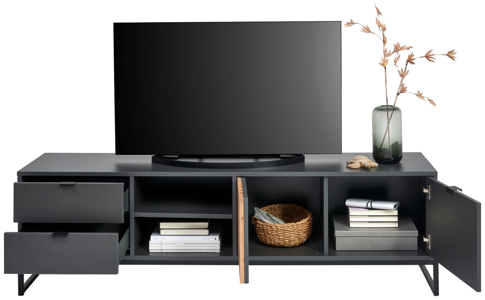 Modernes TV-Lowboard in dunklem Design mit zwei Schubladen links, offenen Fächern in der Mitte und einer Tür rechts, dekoriert mit einem Fernseher, einer Vase und einem Korb, aus frontaler Perspektive.