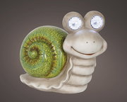 Frontalansicht einer lächelnden Solar-Schnecke aus Polyresin mit leuchtenden Augen und grünem Schneckenhaus.