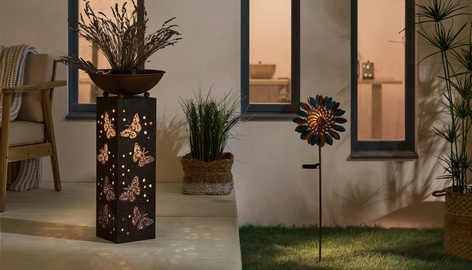 Solarleuchte mit Schmetterlingsmuster, seitliche Perspektive, beleuchtet in einem gemütlichen Gartenambiente.