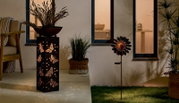 Zonne-lamp met vlinderpatroon, zijaanzicht, verlicht in een gezellige tuinsfeer.
