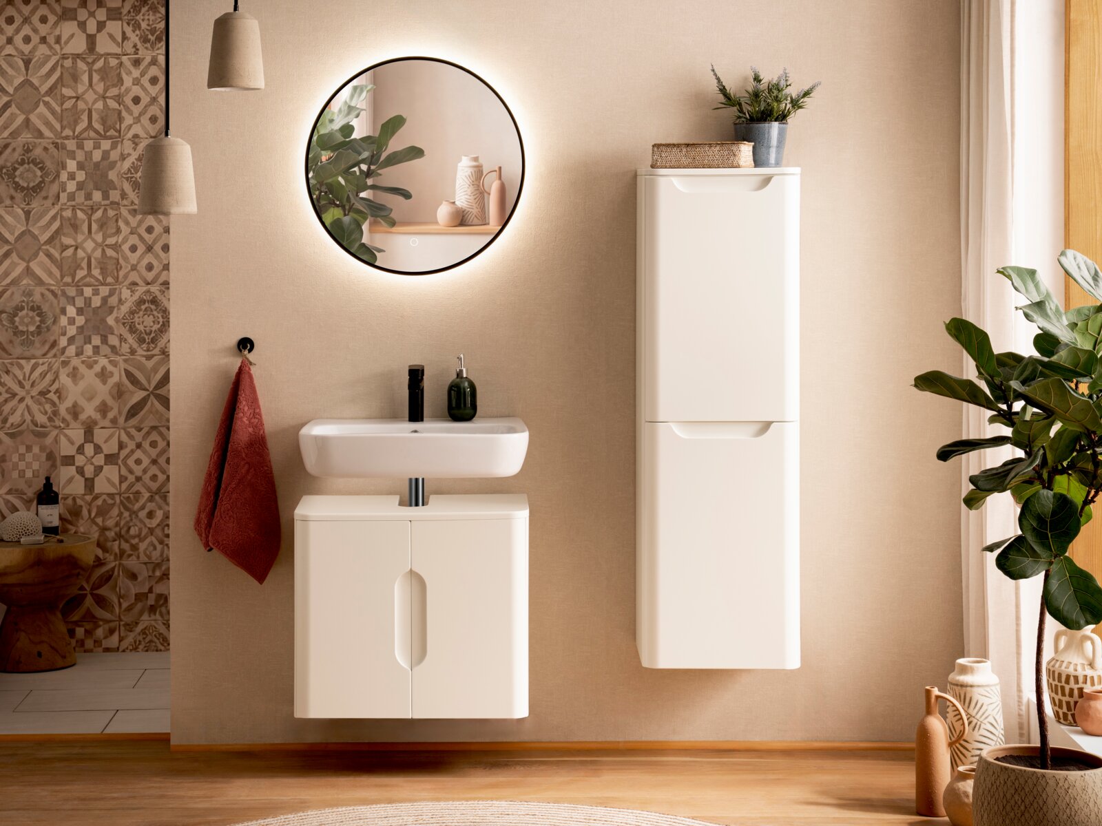 Frontale Ansicht eines modernen Badezimmers mit weißem, wandhängendem Waschtischunterschrank, passendem Hochschrank und rundem Spiegel mit LED-Beleuchtung über dem Waschbecken.