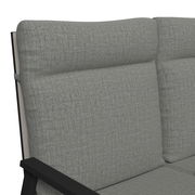 Nahaufnahme einer grauen Gartenbank mit gepolsterten Kissen und schwarzem Metallrahmen, seitliche Perspektive