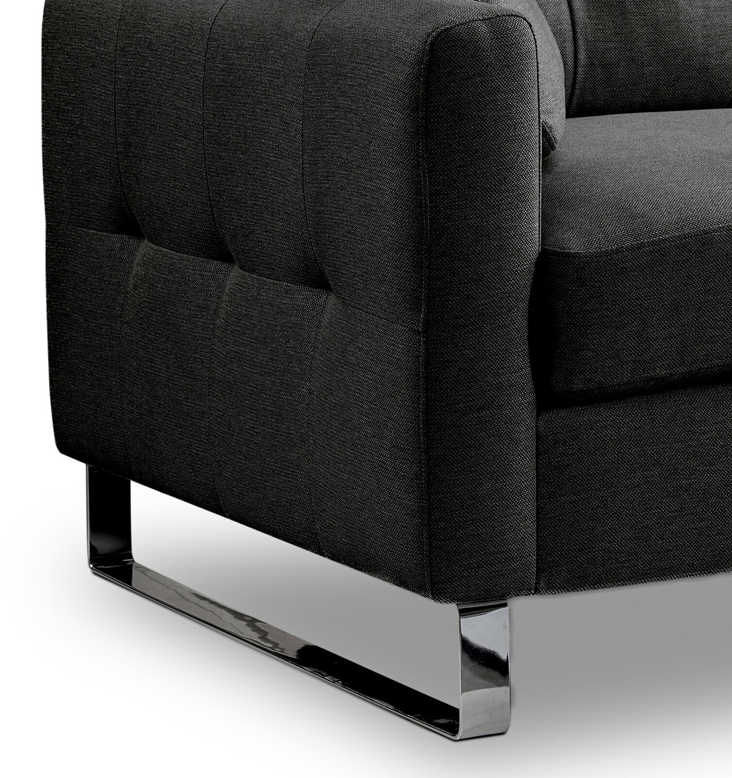 Detailaufnahme eines dunkelgrauen Stoffsofas mit gesteppter Seitenlehne und glänzendem Chrom-Kufengestell, Perspektive schräg von vorne unten