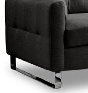 Detailaufnahme eines dunkelgrauen Stoffsofas mit gesteppter Seitenlehne und glänzendem Chrom-Kufengestell, Perspektive schräg von vorne unten