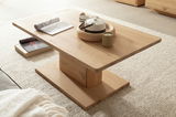 Moderner Couchtisch aus Holz in seitlicher Perspektive, dekoriert mit einer Teekanne, Kerze und Zeitschriften auf einem hellen Teppich.