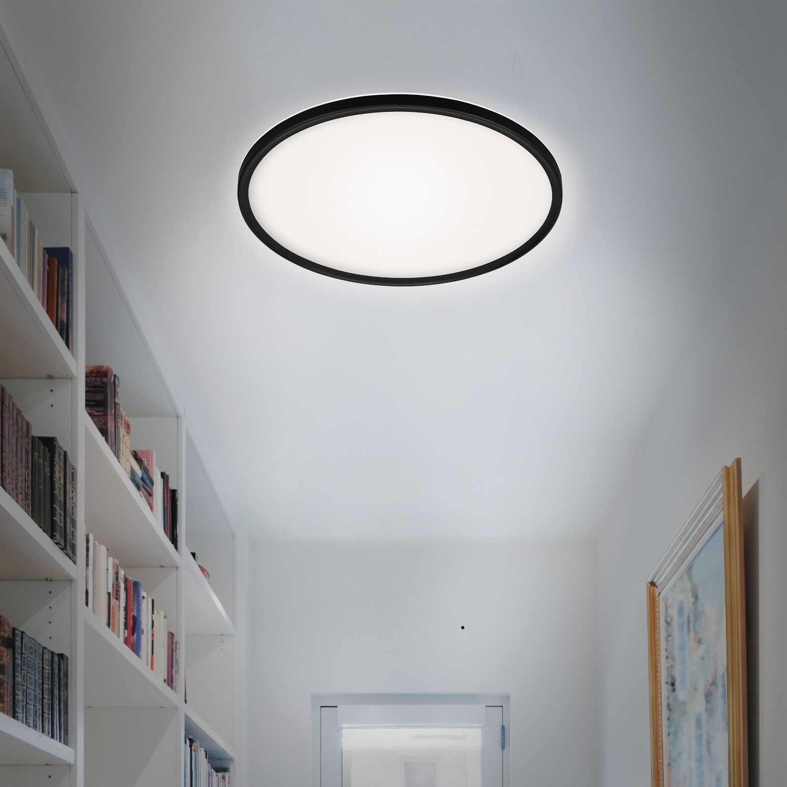 Briloner LED-plafondlamp SLIM Runde LED-Deckenleuchte in einem modernen Flur, von unten betrachtet.