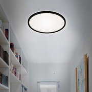 Runde LED-Deckenleuchte in einem modernen Flur, von unten betrachtet.