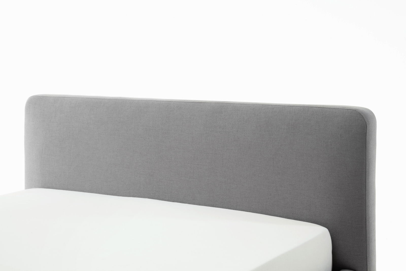 Graues Polsterbett mit schlichtem Kopfteil, seitliche Perspektive