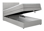 Graues Boxspringbett mit hochgeklappter Matratze und sichtbarem Stauraum, seitliche Perspektive