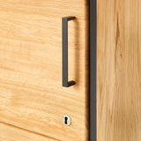 Nahaufnahme eines Aktenschranks aus Holz mit schwarzem Griff und Schlüsselloch, Perspektive von der Seite.
