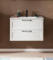 Frontale Ansicht eines modernen Waschtisch-Sets mit zwei Schubladen, weißem Finish und schwarzen Griffen, dekoriert mit Seifenspender und Accessoires.