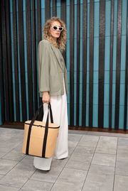 Frau mit Sonnenbrille und beiger Thermoshopper-Tasche, seitliche Perspektive