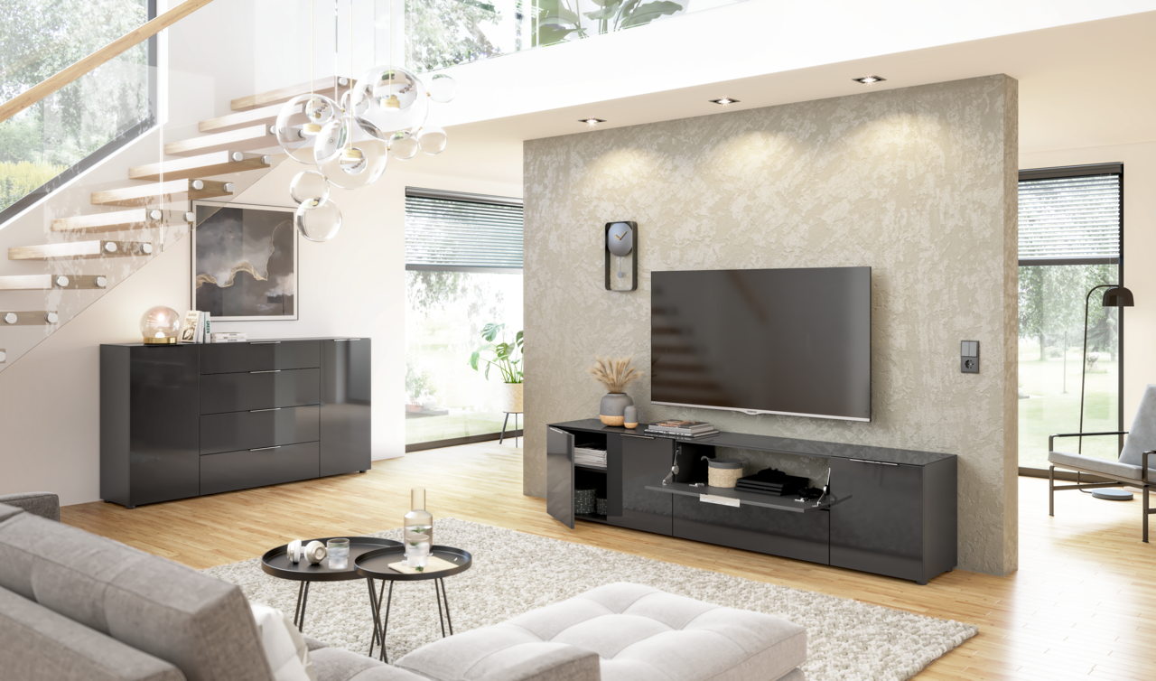 Modernes Wohnzimmer mit einem schwarzen Sideboard und einem TV-Lowboard in Hochglanzoptik, seitliche Perspektive.