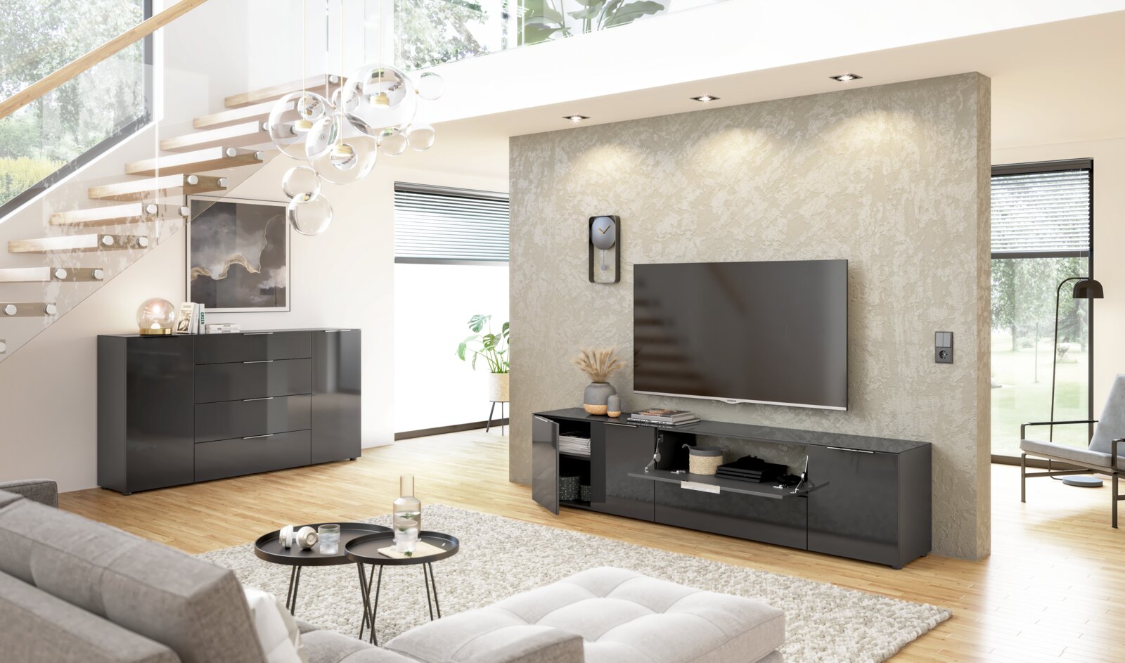 Modernes Wohnzimmer mit einem schwarzen Sideboard und einem TV-Lowboard in Hochglanzoptik, seitliche Perspektive.