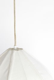 Nahaufnahme einer weißen Hängeleuchte mit Stoffschirm, von unten fotografiert.