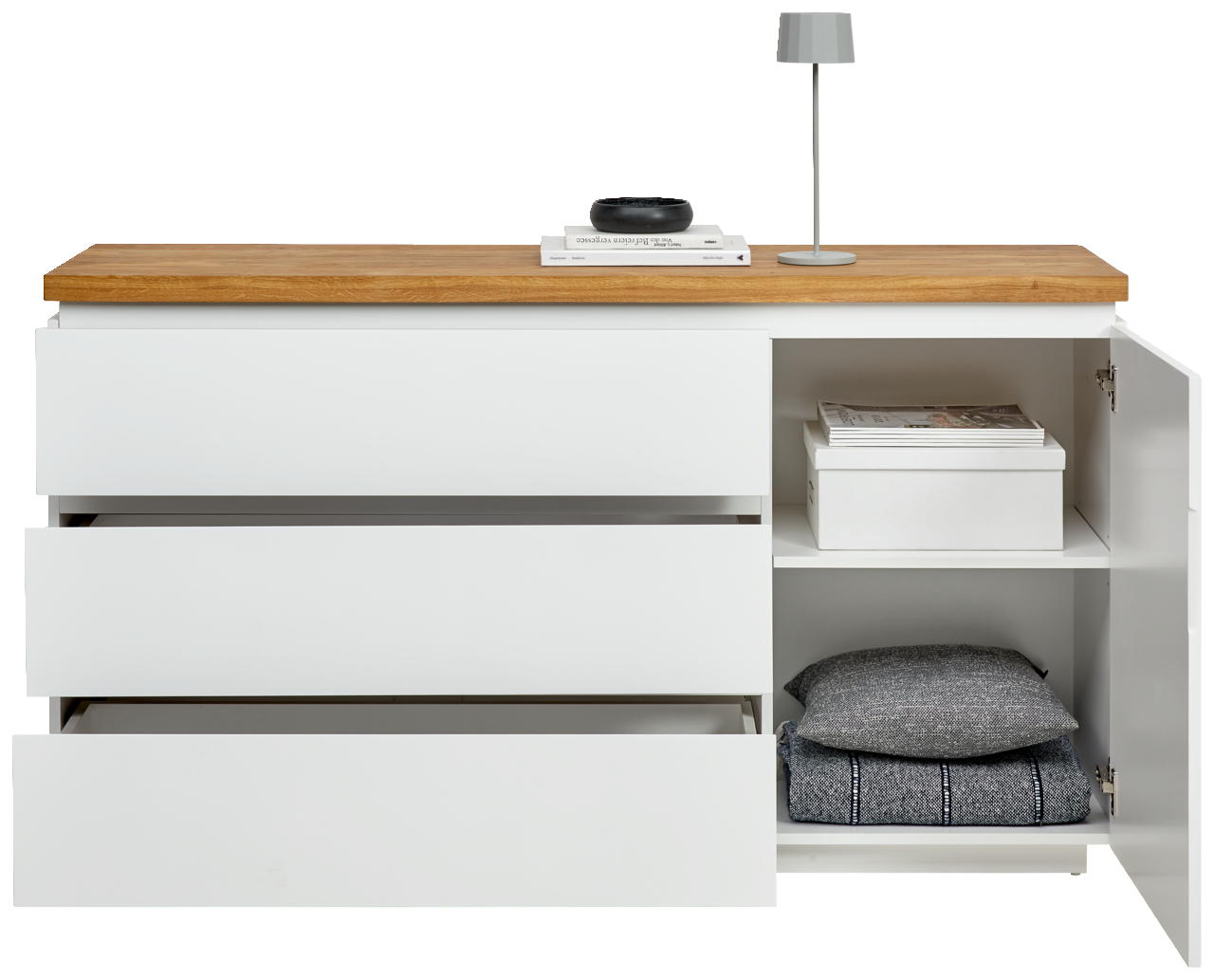 Weißes Sideboard mit drei offenen Schubladen und einem offenen Schrankfach, darauf eine Lampe und Bücher, frontale Ansicht