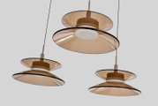 Drie moderne hanglampen met dubbele schijven van amberkleurig transparant glas en witte lichtdiffuser, vanuit onderaanzicht tegen een lichtgrijze achtergrond