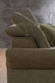 Seitenansicht einer braunen Rundecke mit verstellbarer Rückenlehne vor einer grauen Wand.