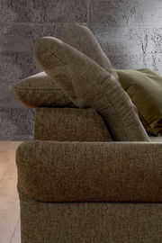 Seitenansicht einer braunen Rundecke mit verstellbarer Rückenlehne vor einer grauen Wand.