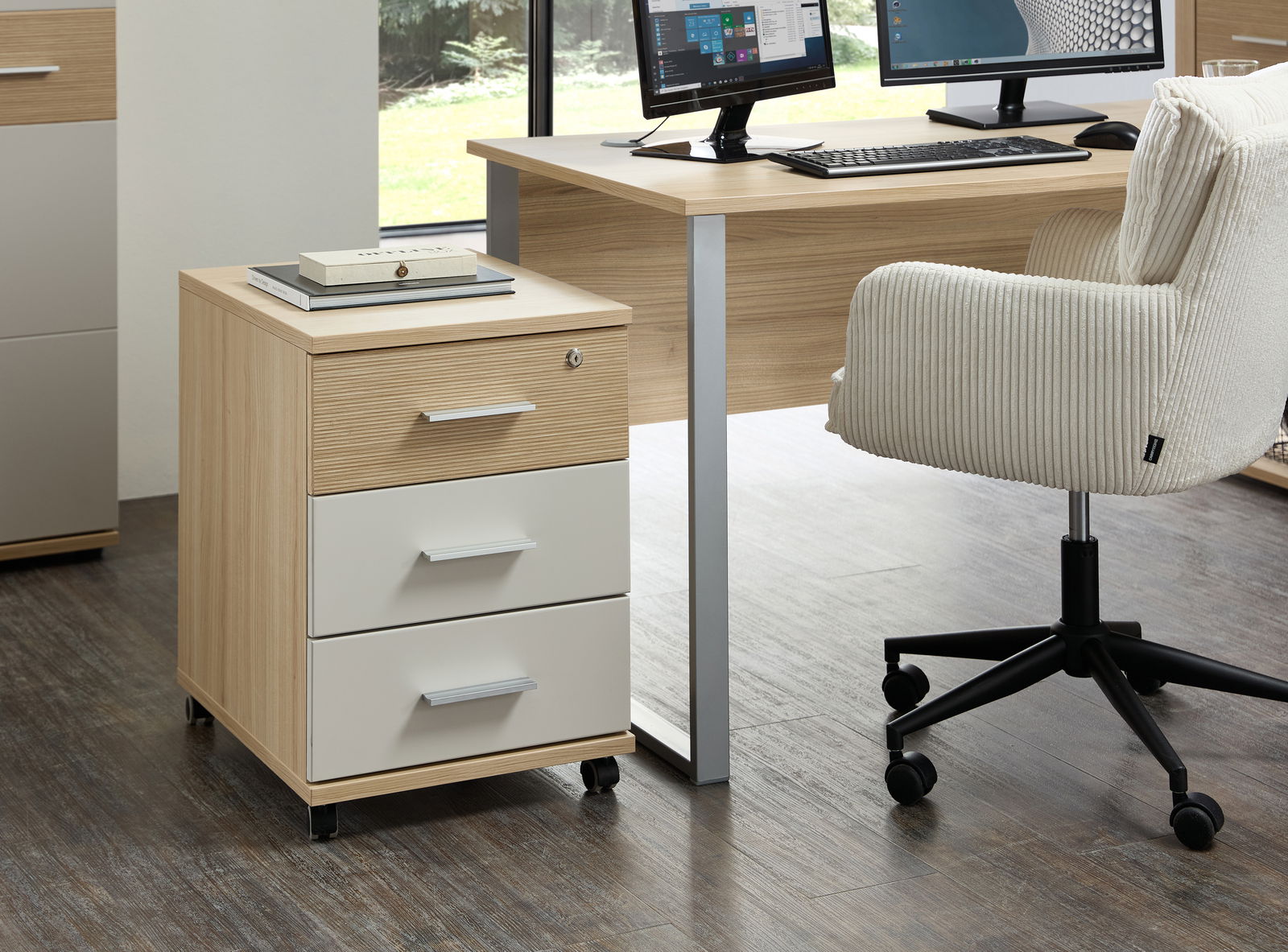 Rollcontainer mit drei Schubladen in Holzoptik und weißen Fronten, auf Rollen, seitliche Perspektive im Büro.