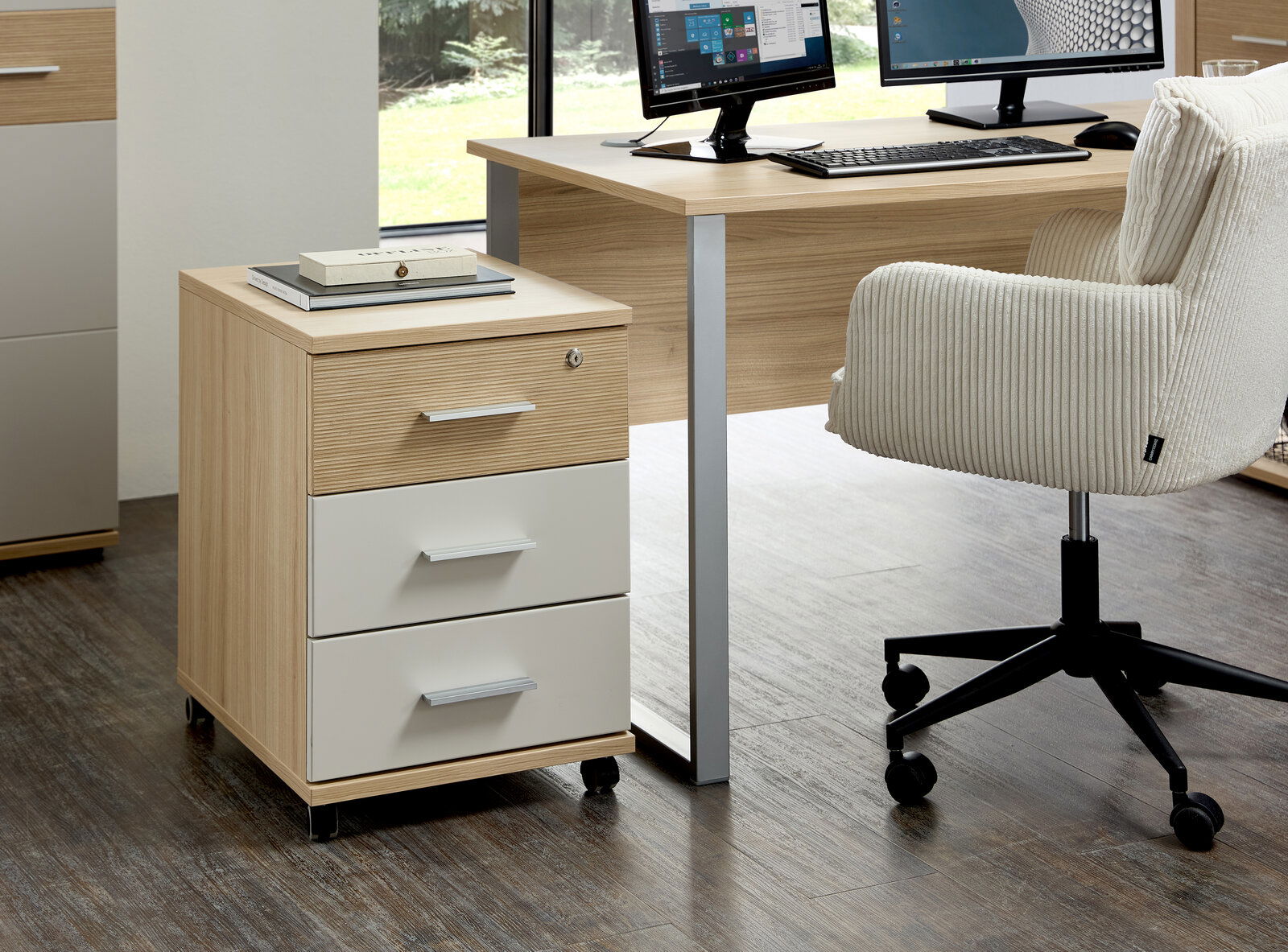 Rollcontainer mit drei Schubladen in Holzoptik und weißen Fronten, auf Rollen, seitliche Perspektive im Büro.