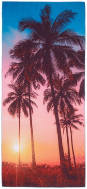 Strandtuch mit Palmenmotiv bei Sonnenuntergang, aus der Vogelperspektive fotografiert.