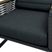 Nahaufnahme eines modernen Gartensessels mit dunklem Stoffbezug und seitlichen Armlehnen aus Holz, seitliche Perspektive