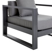 Moderner Lounge-Sessel mit grauem Metallrahmen und grauen Kissen, seitliche Perspektive