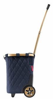 Seitenansicht eines blauen Carrycruisers mit rhombenförmigem Muster, goldfarbenem Teleskopgriff und schwarzen Rädern.