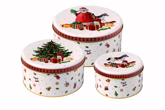 Drei runde Keksdosen mit weihnachtlichen Motiven, darunter ein Weihnachtsmann, ein Weihnachtsbaum und Geschenke, aus einer leicht erhöhten Perspektive fotografiert.