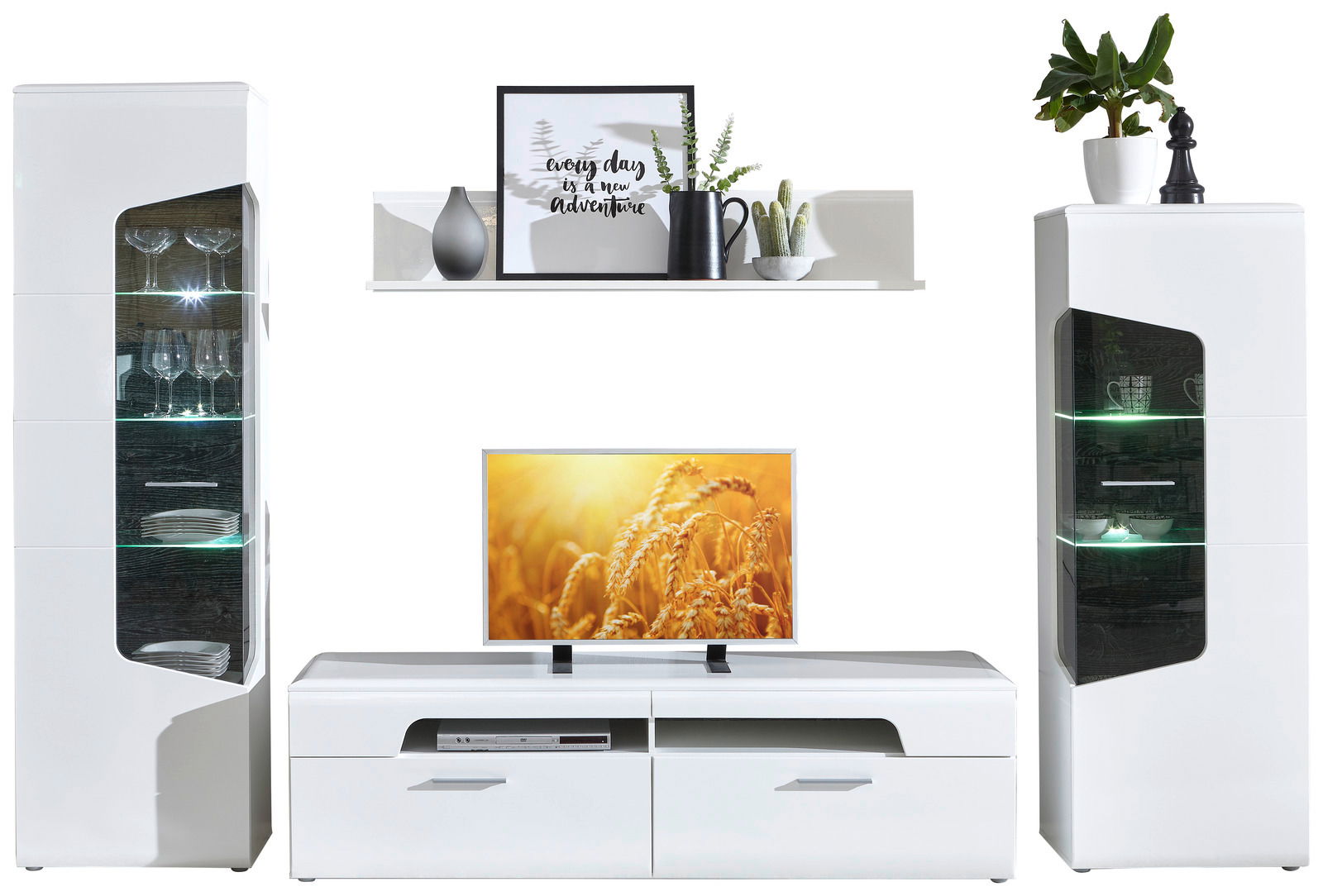 Wohnzimmermöbel-Set bestehend aus zwei Vitrinen, einem TV-Lowboard und einem Wandboard, frontal betrachtet. Die Vitrinen haben Glaseinsätze mit Beleuchtung, das TV-Lowboard bietet Platz für Unterhaltungselektronik, und das Wandboard ist dekorativ mit Pfla