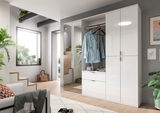 Moderner weißer Hochschrank mit glänzender Oberfläche, teilweise geöffnet, zeigt Innenraum mit Kleiderstange und Schubladen, Perspektive von schräg vorne.