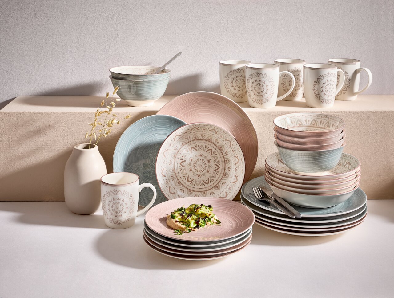 Porzellan-Set Valencia 30-teilig in sanften Pastelltönen, bestehend aus Tellern, Schalen und Tassen mit dekorativem Muster, seitliche Perspektive.