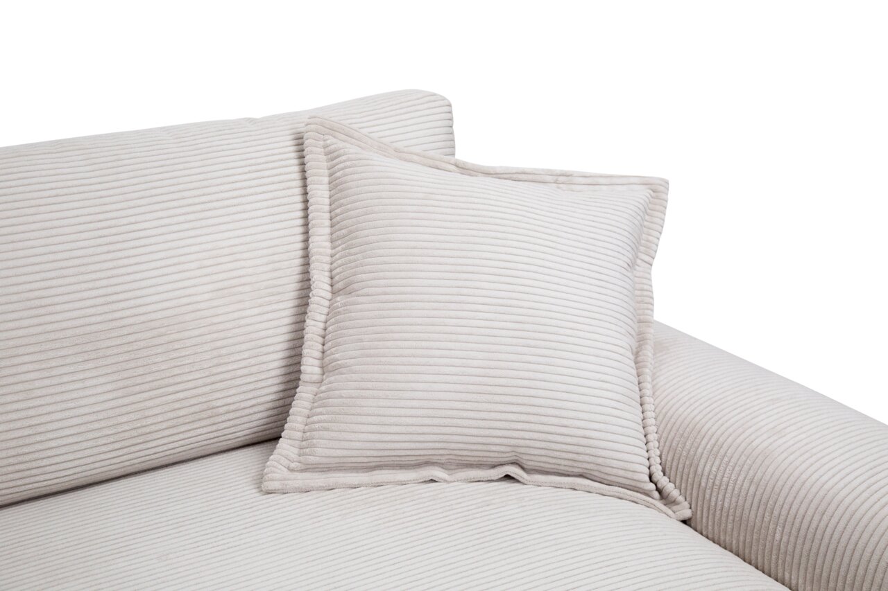 Close-up van een beige grote bank met geribbelde bekleding en bijpassende kussens, gezien vanaf de zijkant
