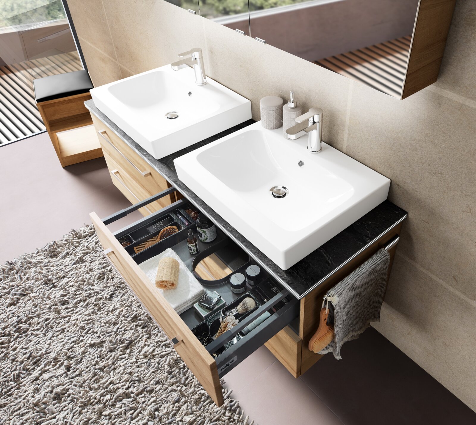 Modernes Badezimmer-Doppelwaschbecken mit zwei weißen Aufsatzwaschschalen auf dunkler Steinplatte und Holz-Waschtischunterschrank, Schublade geöffnet mit Organizer; Perspektive: schräg von oben (Aufsicht)