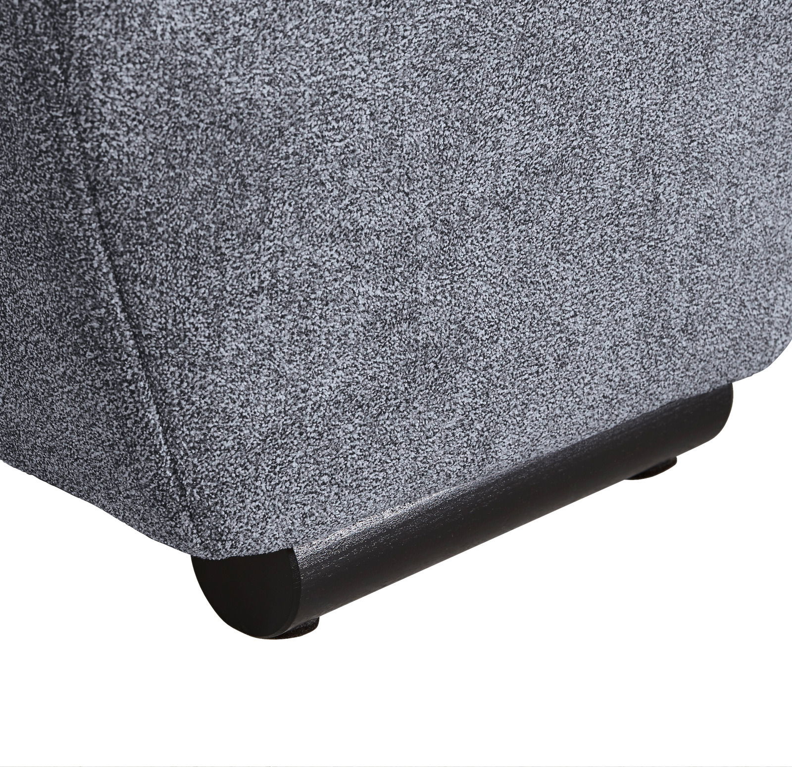 Nahaufnahme der unteren Ecke eines grauen Big-Sofas mit schwarzem Fuß, seitliche Perspektive.