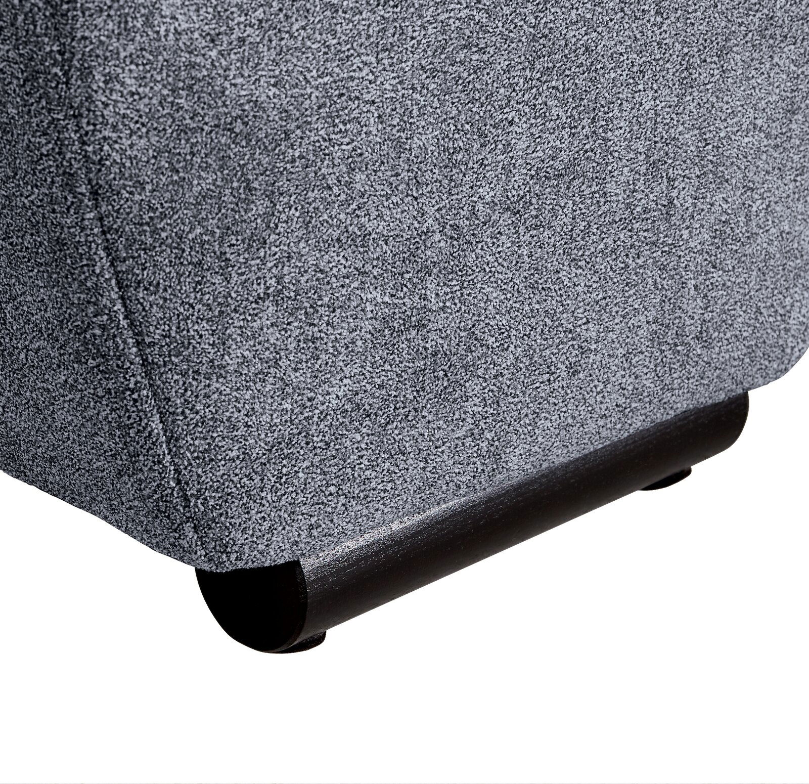 Nahaufnahme der unteren Ecke eines grauen Big-Sofas mit schwarzem Fuß, seitliche Perspektive.