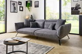 Graues Megasofa mit Kissen in modernem Wohnzimmer, seitliche Perspektive